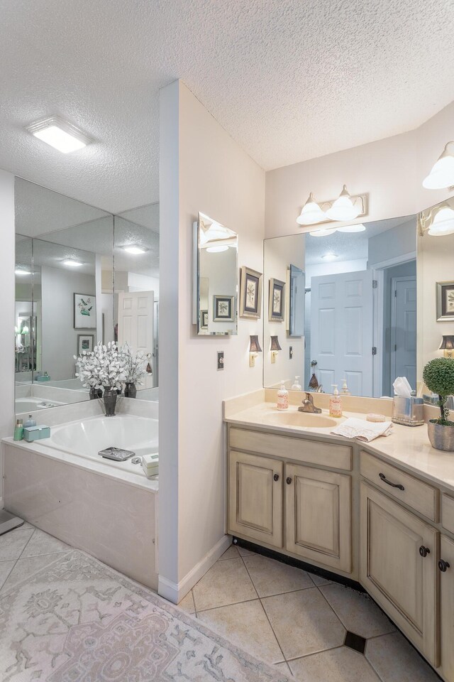 bathroom featuring vanity, a tub to relax in, a textured ceiling, and tile patterned flooring