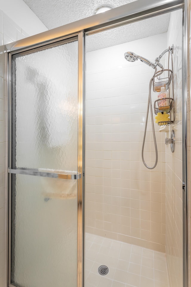 bathroom with a textured ceiling and walk in shower