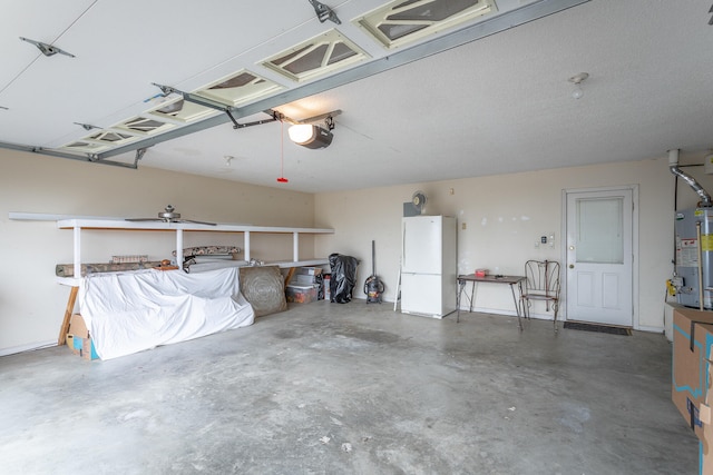 garage with a garage door opener, water heater, and white refrigerator