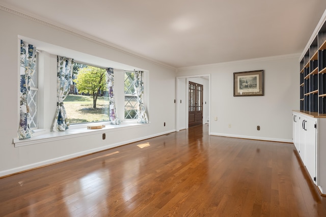 unfurnished room with ornamental molding and dark wood-type flooring