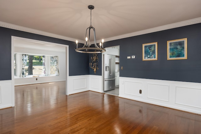 unfurnished dining area with ornamental molding, hardwood / wood-style floors, and a notable chandelier