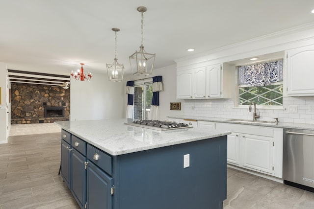 kitchen featuring appliances with stainless steel finishes, a center island, white cabinetry, and sink