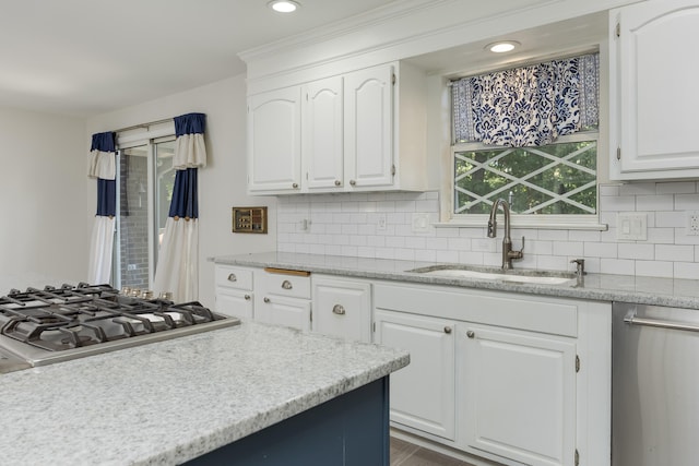 kitchen featuring backsplash, stainless steel appliances, white cabinetry, and sink