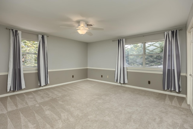 carpeted spare room featuring ceiling fan