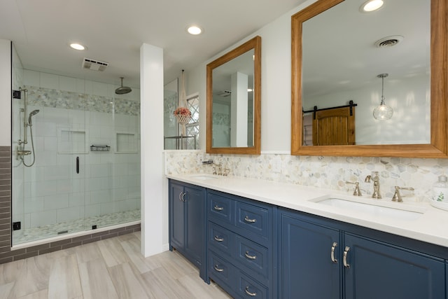 bathroom with backsplash, a shower with shower door, and vanity