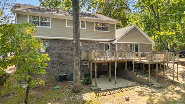 back of house featuring a wooden deck and a patio