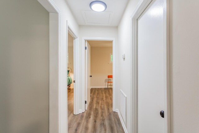 corridor with hardwood / wood-style flooring