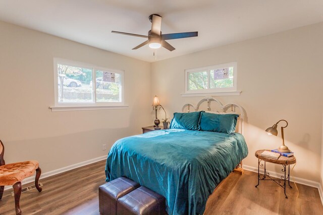 bedroom with ceiling fan, hardwood / wood-style floors, and multiple windows