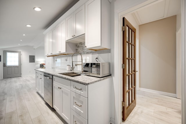 kitchen featuring dishwasher, decorative backsplash, white cabinetry, and lofted ceiling