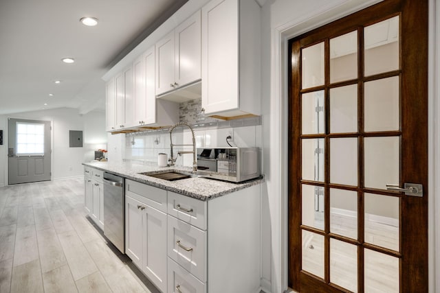 kitchen with dishwasher, tasteful backsplash, white cabinets, and light stone countertops