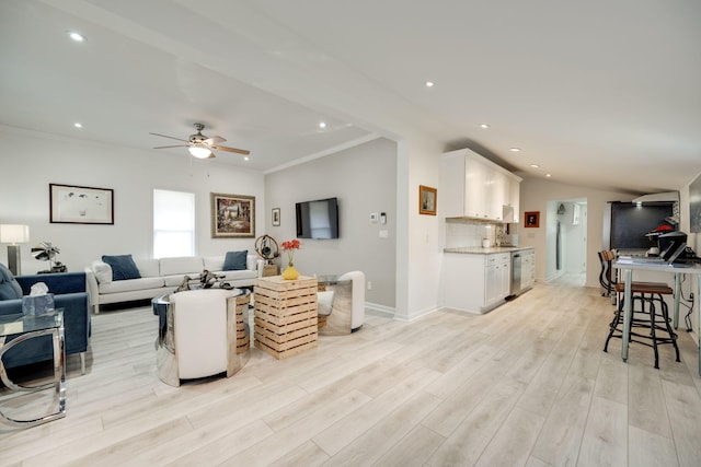 living room with ceiling fan, ornamental molding, and light hardwood / wood-style flooring