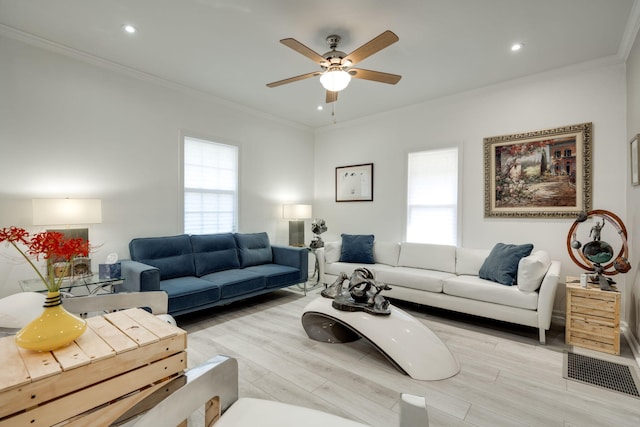 living room featuring crown molding, light hardwood / wood-style flooring, ceiling fan, and plenty of natural light