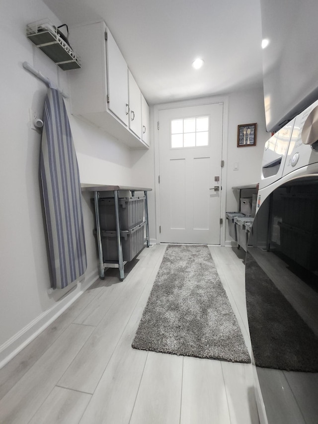 clothes washing area with cabinets