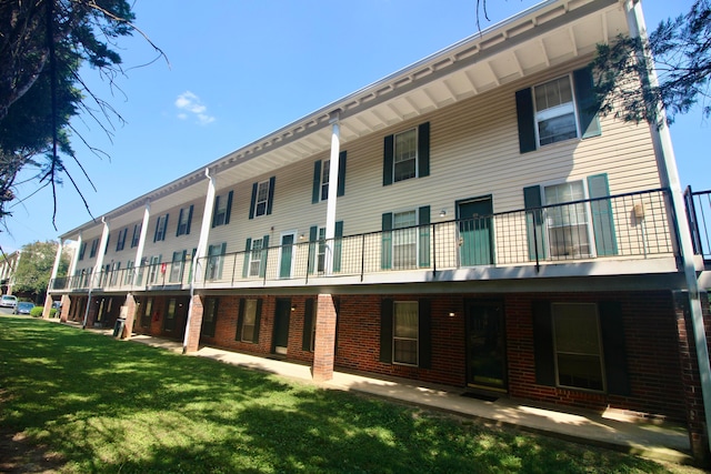 back of property with a balcony and a lawn