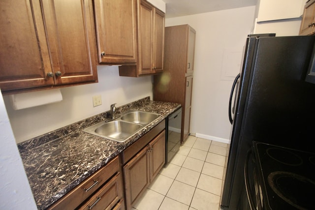 kitchen featuring light tile patterned floors, dark stone counters, sink, and black appliances