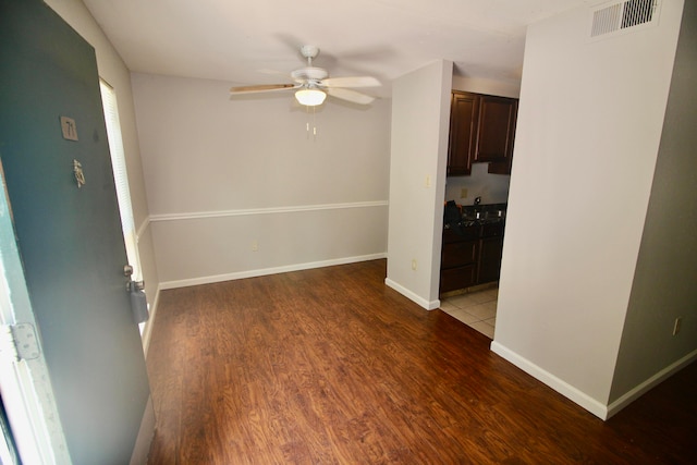 empty room featuring ceiling fan and dark wood-type flooring