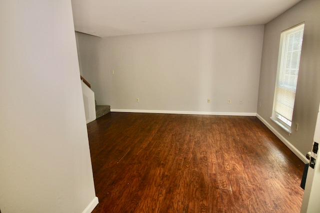 unfurnished room with dark hardwood / wood-style flooring and a wealth of natural light