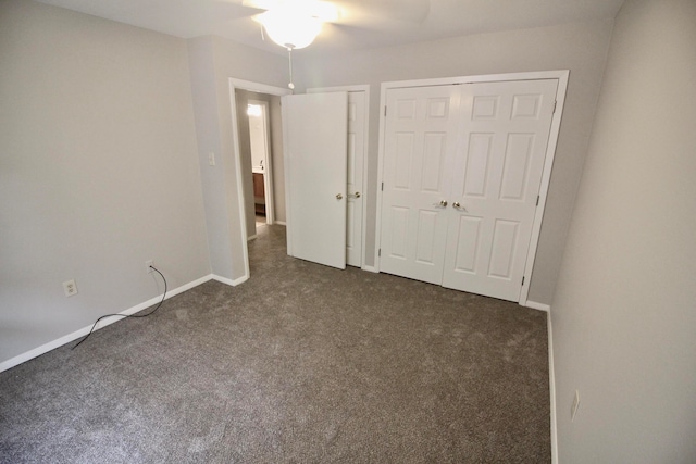 unfurnished bedroom with dark carpet, a closet, and ceiling fan