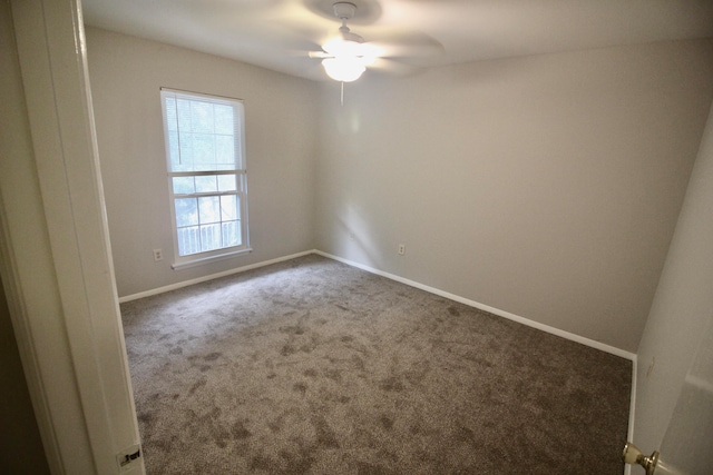 carpeted spare room featuring ceiling fan