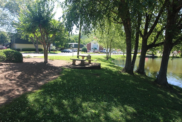 view of home's community with a lawn and a water view