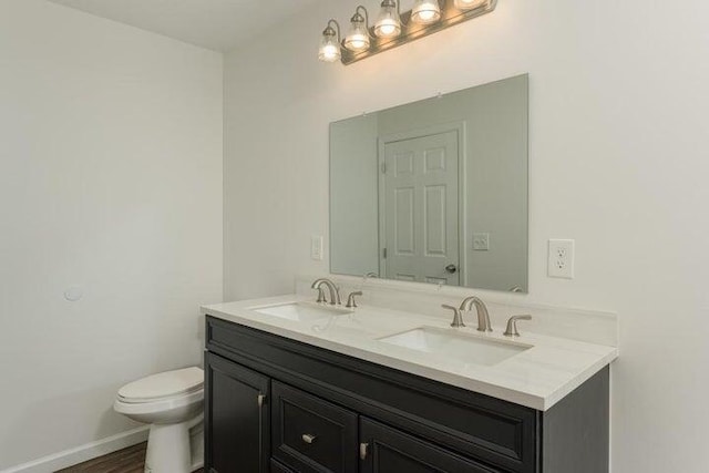 bathroom featuring toilet, vanity, and hardwood / wood-style floors