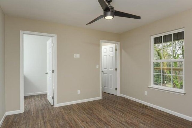 unfurnished room featuring dark wood-type flooring and ceiling fan