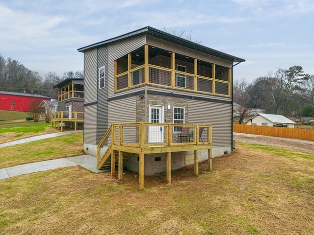 back of house with a wooden deck and a lawn