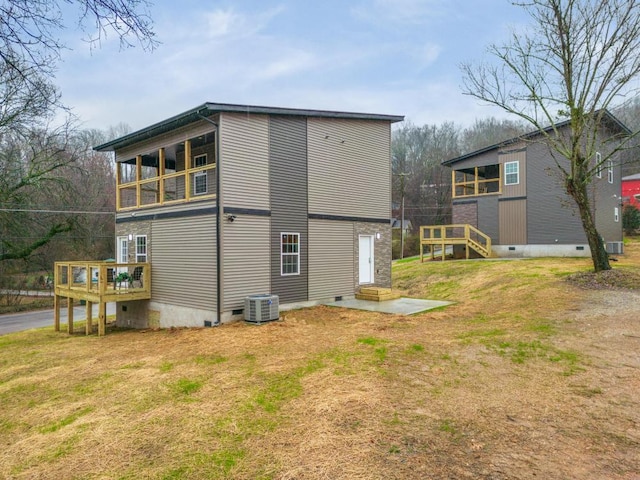 rear view of house with a wooden deck, cooling unit, a yard, and a balcony