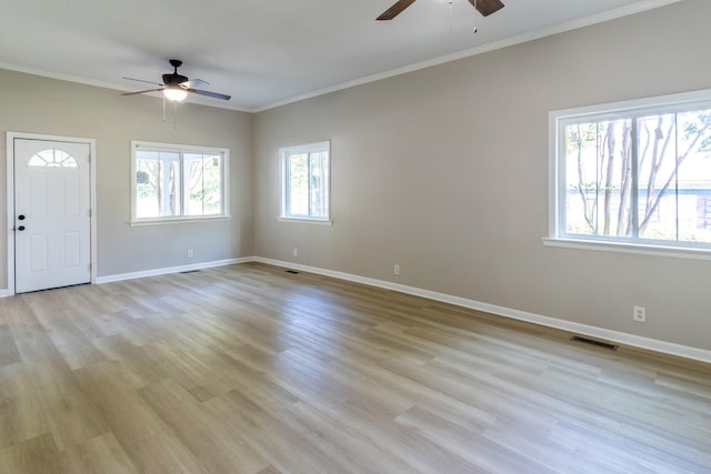 interior space featuring ceiling fan, light wood-type flooring, and ornamental molding