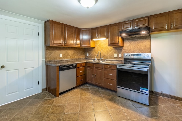 kitchen featuring dark tile patterned floors, sink, stainless steel appliances, and tasteful backsplash