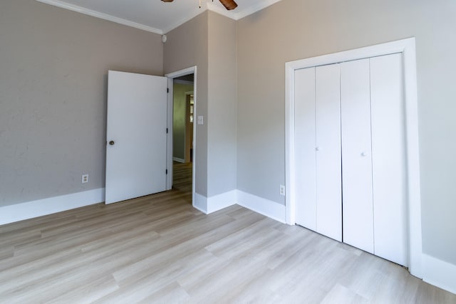 unfurnished bedroom with light wood-type flooring, a closet, ceiling fan, and crown molding