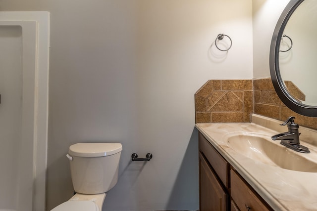 bathroom with vanity, backsplash, and toilet