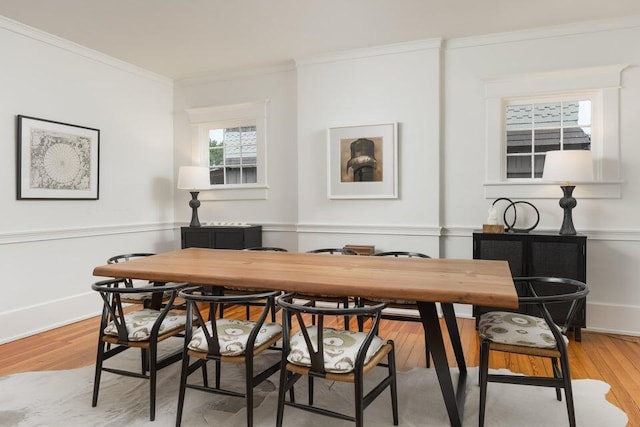 dining area with crown molding and light hardwood / wood-style floors