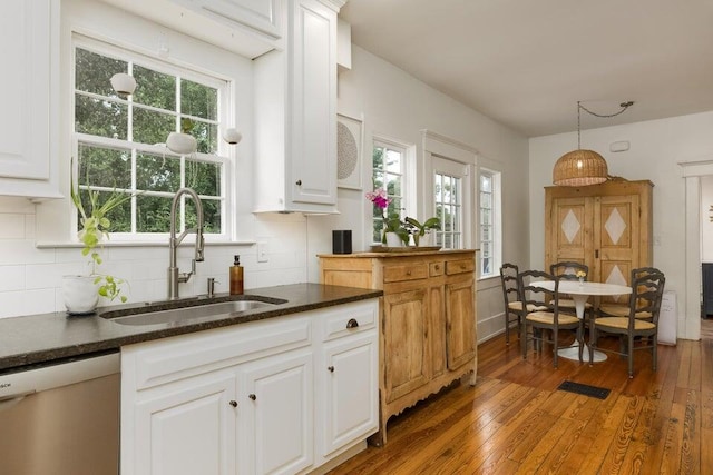 kitchen featuring pendant lighting, sink, white cabinetry, dishwasher, and dark hardwood / wood-style floors