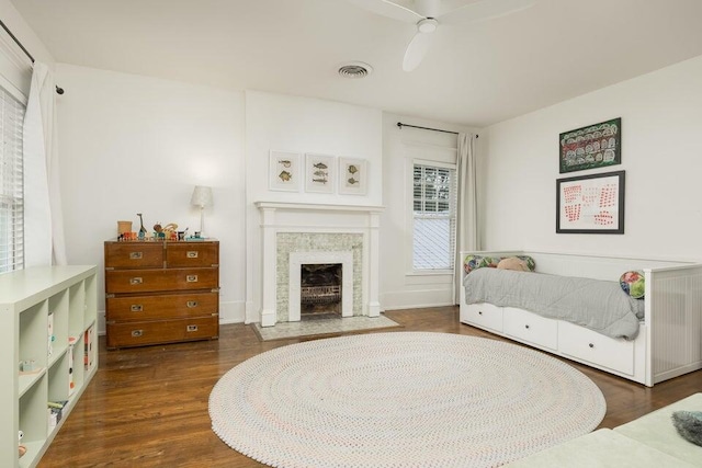 bedroom with multiple windows, dark hardwood / wood-style flooring, and ceiling fan