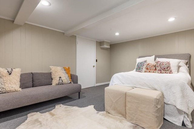 carpeted bedroom with beamed ceiling and wooden walls