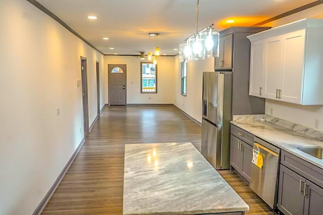 kitchen with appliances with stainless steel finishes, decorative light fixtures, dark wood-type flooring, and white cabinets