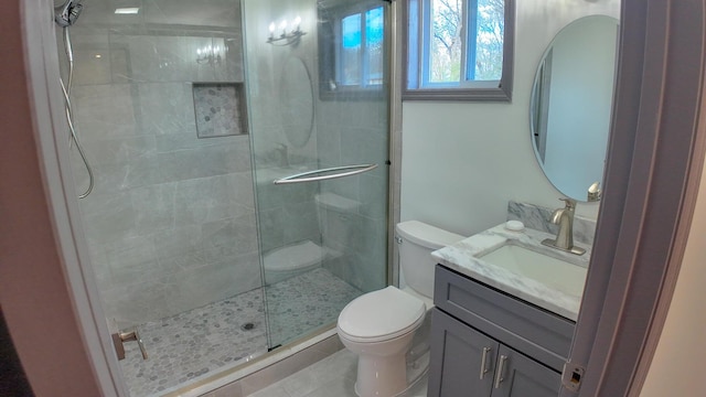 bathroom featuring vanity, toilet, tile patterned flooring, and a shower with door