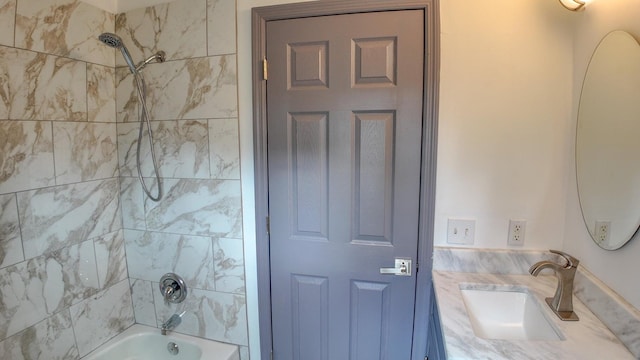 bathroom with tiled shower / bath combo and vanity