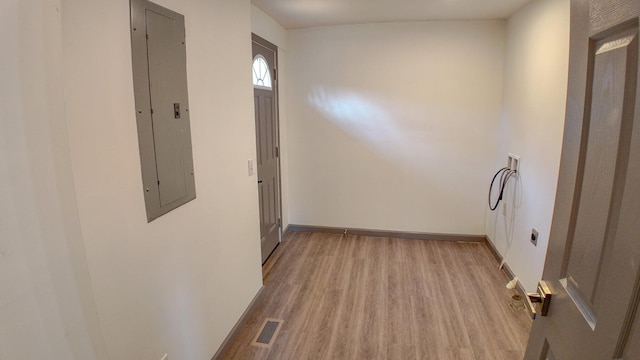 corridor featuring electric panel and light hardwood / wood-style floors