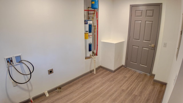 laundry area with electric water heater, washer hookup, electric dryer hookup, and light hardwood / wood-style floors