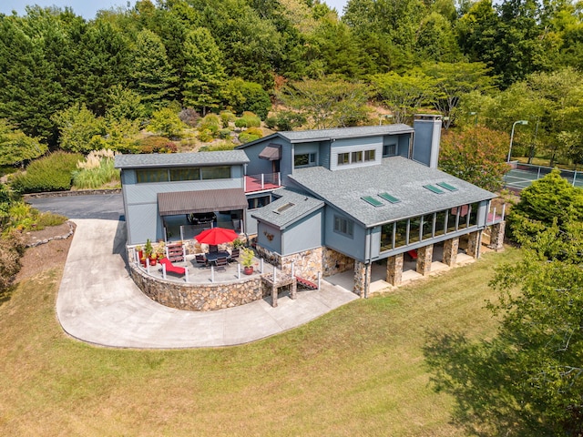 back of house with a lawn and a patio