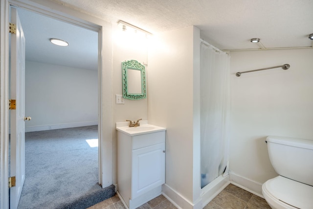 bathroom with vanity, toilet, a shower with shower curtain, and a textured ceiling