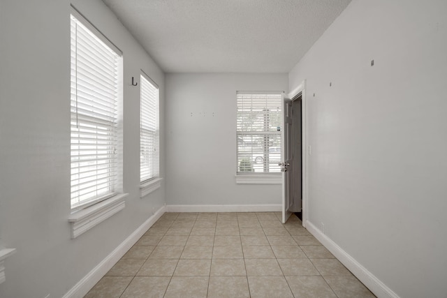 unfurnished room featuring light tile patterned floors and a textured ceiling