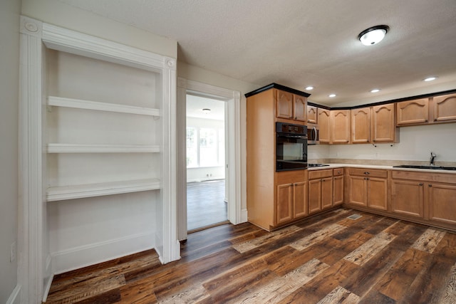 kitchen with black oven, dark hardwood / wood-style flooring, a textured ceiling, and sink