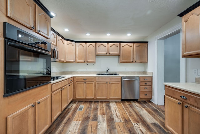 kitchen featuring dark wood-type flooring, a textured ceiling, stainless steel appliances, and sink