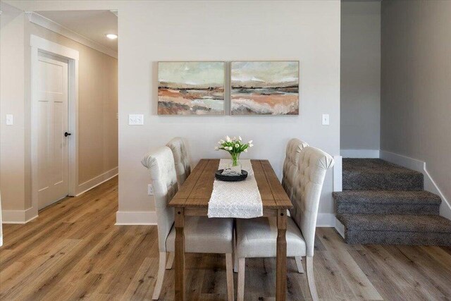 dining room featuring wood-type flooring and ornamental molding