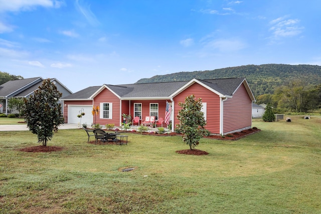 ranch-style house with a mountain view, a front yard, and a garage