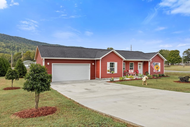 ranch-style home featuring a front yard, a mountain view, and a garage