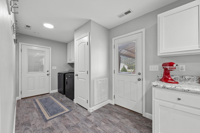 kitchen with separate washer and dryer, dark hardwood / wood-style flooring, light stone counters, and white cabinets